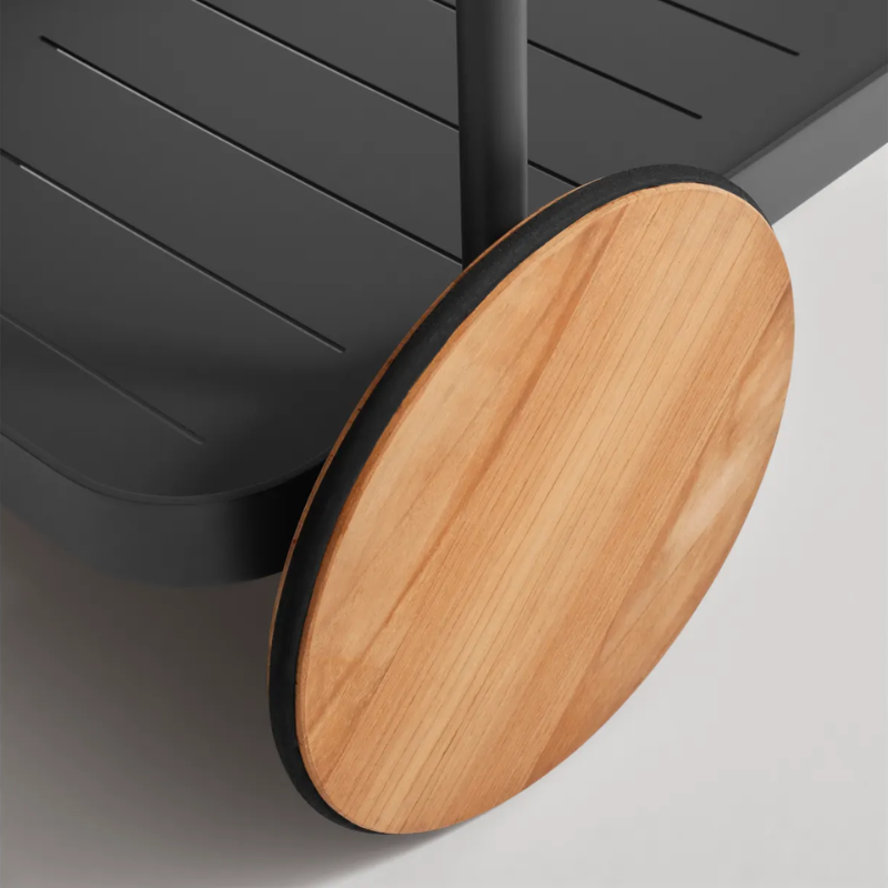 The Longday Bar Cart from Blu Dot in carbon focusing on the teak wheel.