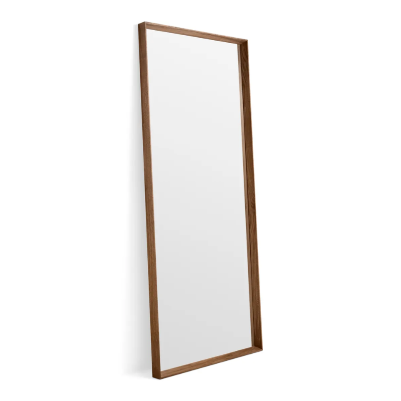 The Mode Large Mirror from Blu Dot in walnut leaning on a wall.