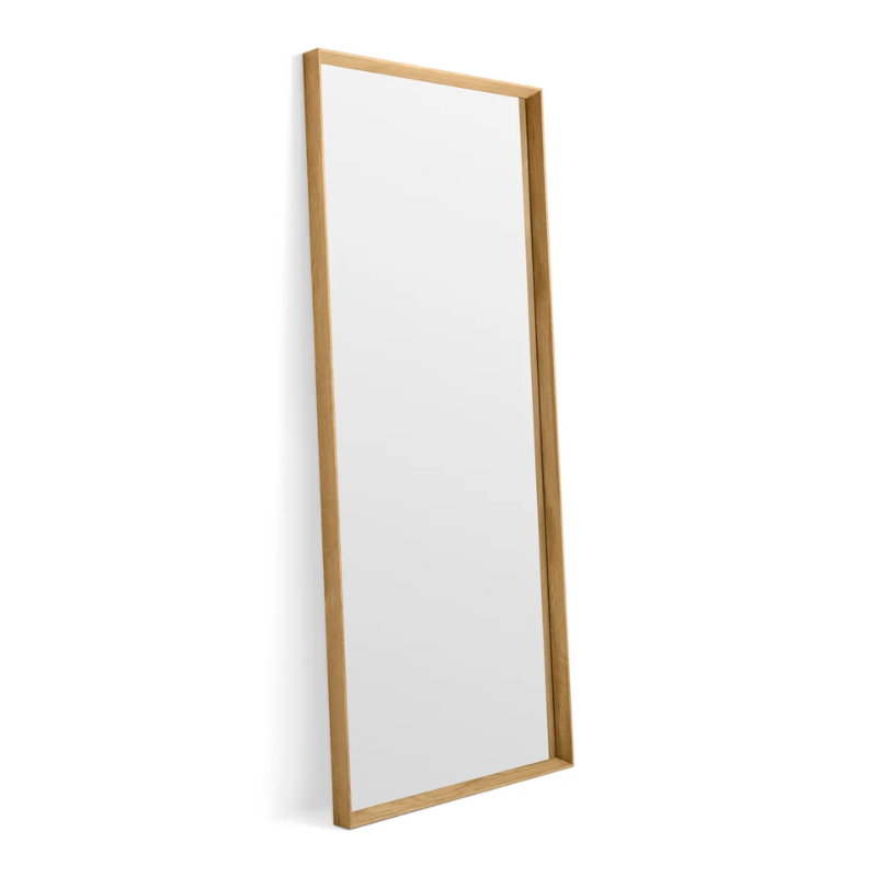 The Mode Large Mirror from Blu Dot in white oak leaning against a wall.