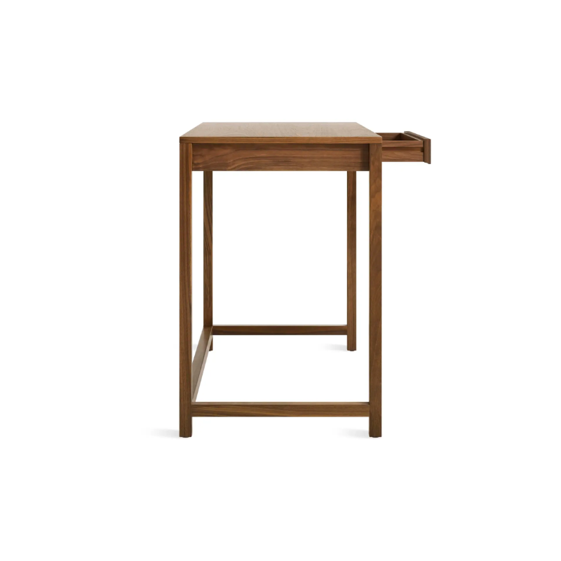 The small Open Plan Desk from Blu Dot in walnut from the side with an open drawer.