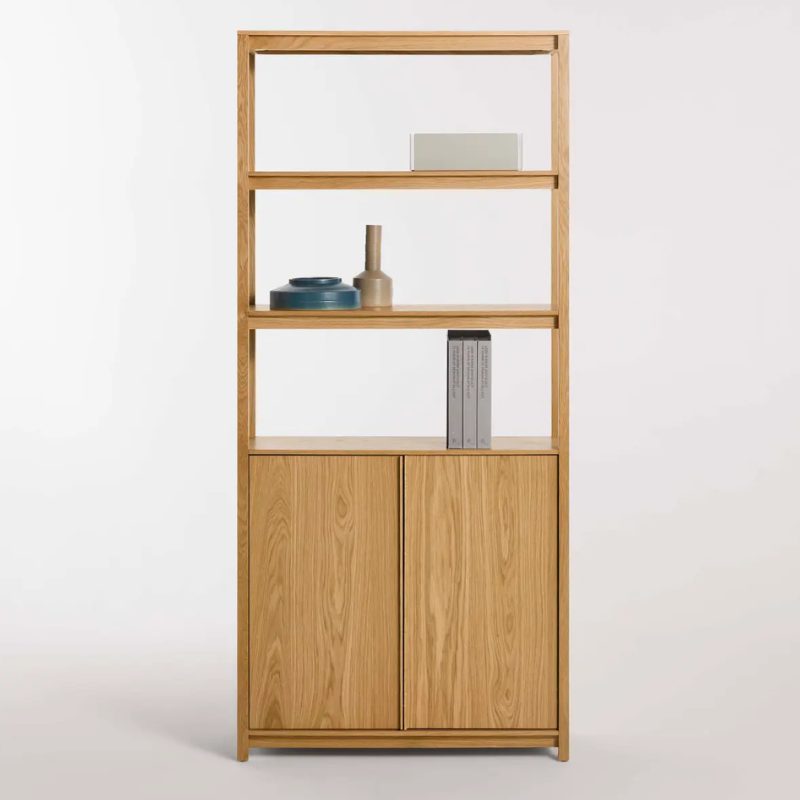 The Open Plan Tall Bookcase with Storage from Blu Dot in white oak in a studio.