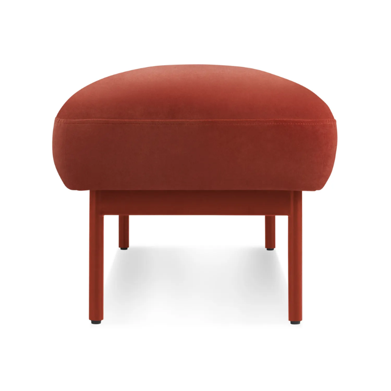 The Puff Puff Bench from Blu Dot with tomato velvet upholstery from the side.