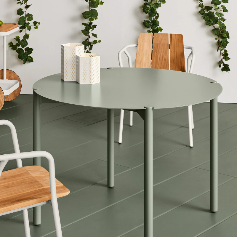 The Round Comeuppance Dining Table from Blu Dot in grey green in a dining room.