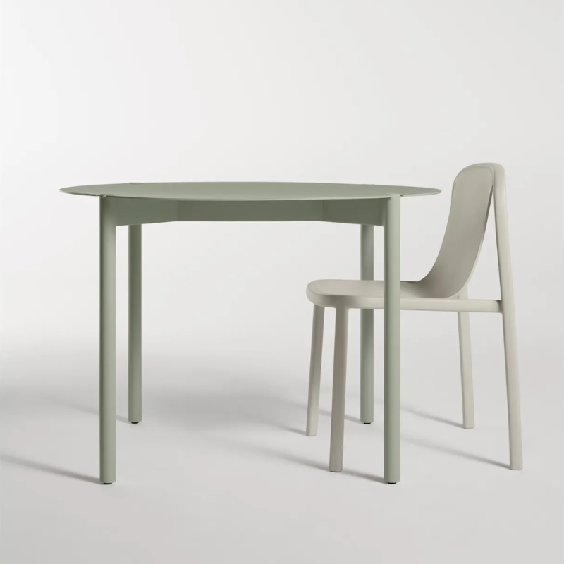 The Round Comeuppance Dining Table from Blu Dot in grey green in a studio.