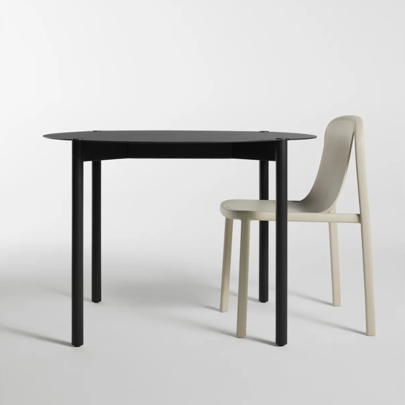 The Round Comeuppance Dining Table from Blu Dot in oblivion in a living room.