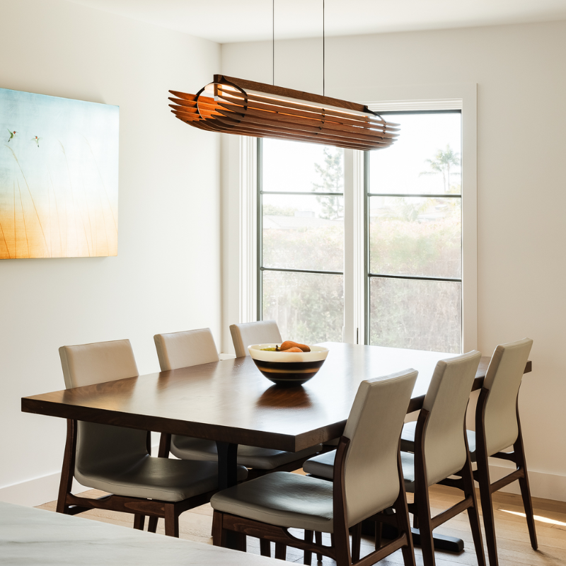 The Lex Linear Pendant from Cerno in walnut in a dining room.