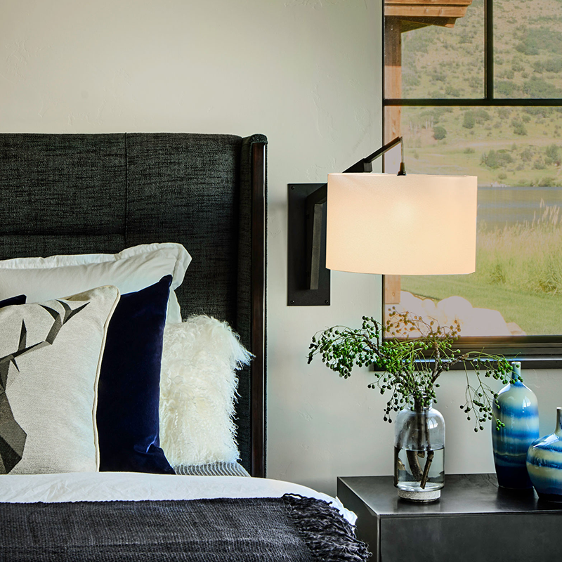 The Talea Wall Sconce Swing Arm from Cerno in White Linen with textured black powder and dark stained walnut in a primary bedroom.