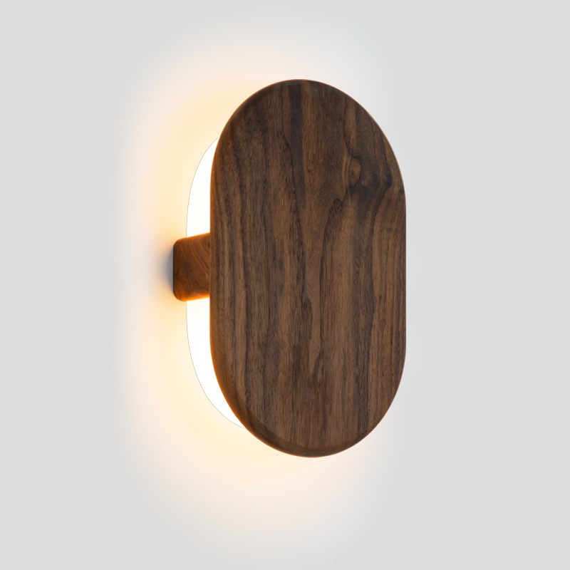 The Tempus Wall Sconce from Cerno in walnut in a studio.