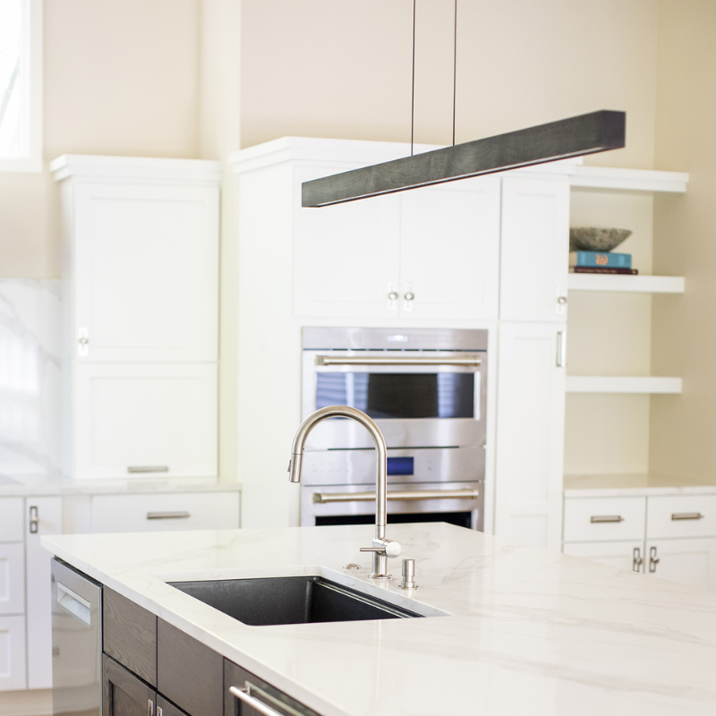 The Una LED Linear Suspension – Uplight and Downlight from Cerno in dark stained walnut in a kitchen.