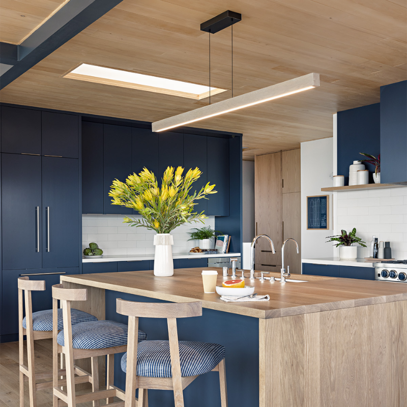 The Una LED Linear Suspension – Uplight and Downlight from Cerno in white washed oak in a kitchen and dining setting.