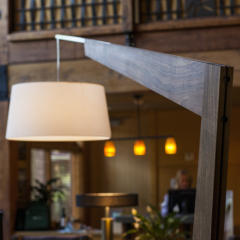 The Valeo Floor Lamp from Cerno in dark stained walnut in a commercial space.