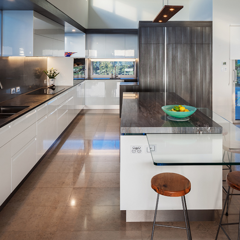 The Vix Linear Pendant from Cerno in walnut above a counter island.
