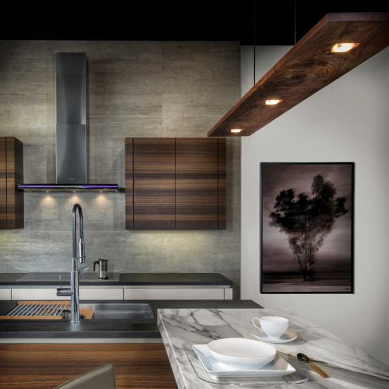 The Vix Linear Pendant from Cerno in walnut above a kitchen bar.