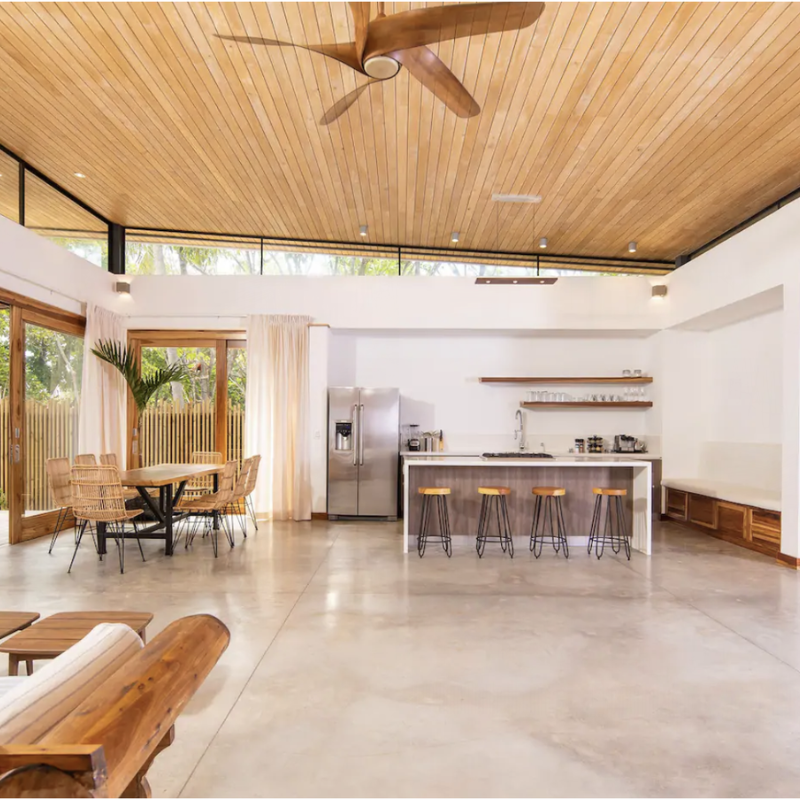 The Vix Linear Pendant from Cerno in walnut in a lounge.