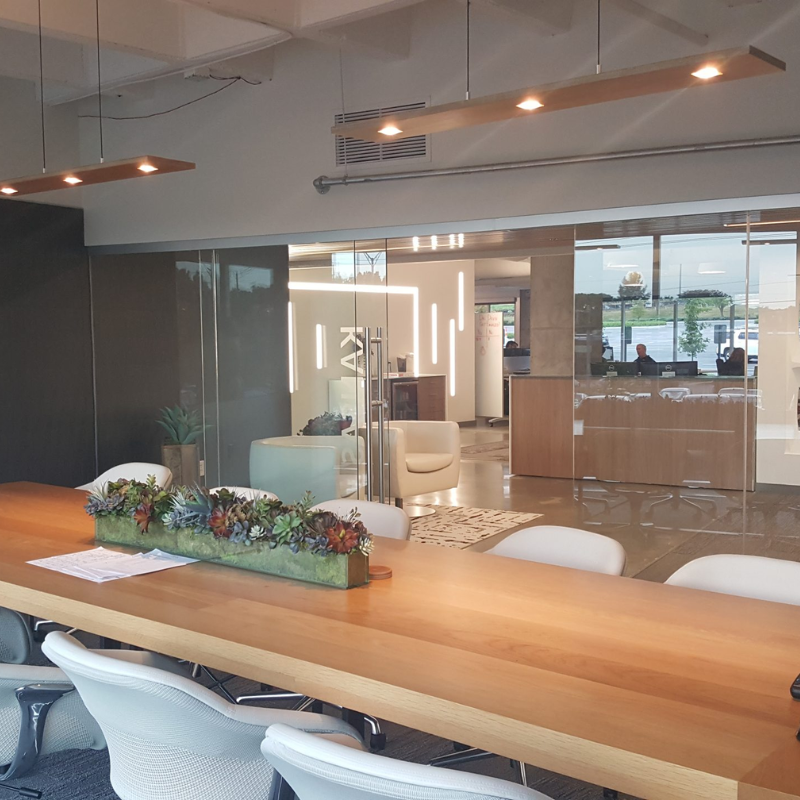 The Vix Linear Pendant from Cerno in walnut in a meeting room.