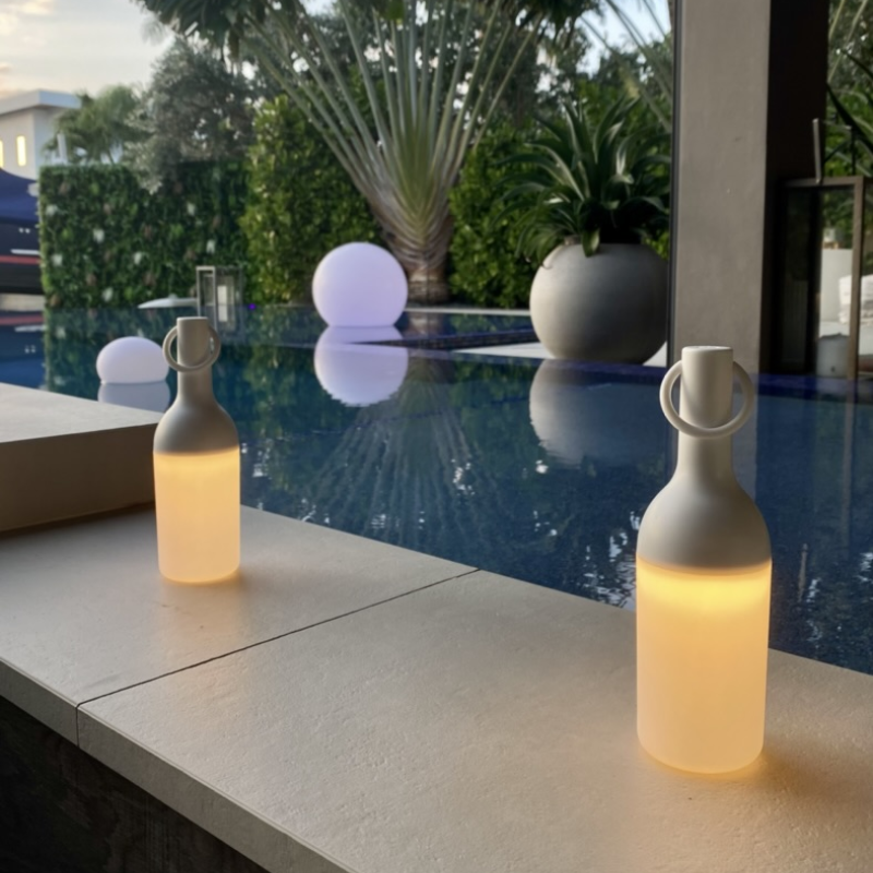 The ELO Baby Portable Table Lamp, Set of 2 by Bina Baitel for DesignerBox next to a pool.