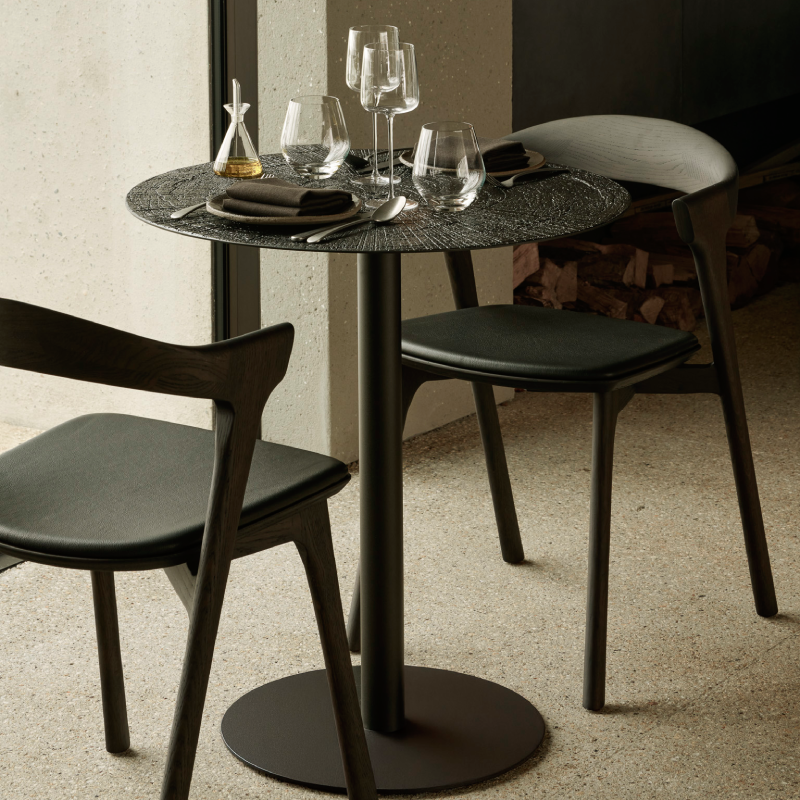 The Blend Dining Table from Ethnicraft in raw whisky in a dining room.