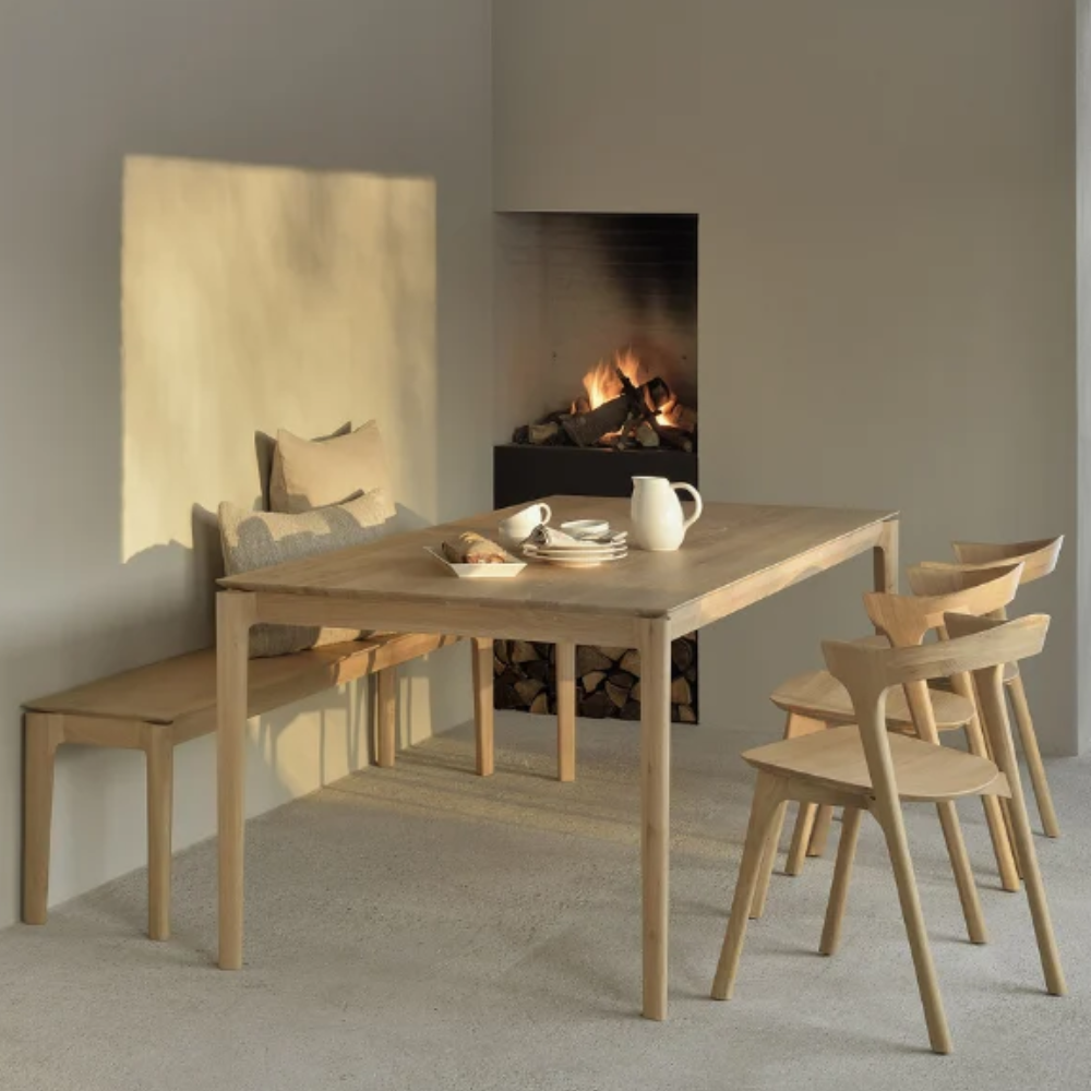 Ethnicraft's Bok dining collection featuring a dining table, chairs and a bench.