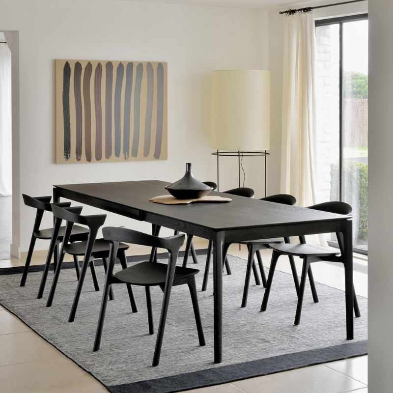 The Bok Extendable Dining Table from Ethnicraft in black oak in a dining room.