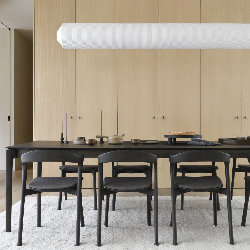 The Bok Extendable Dining Table from Ethnicraft in brown oak in a dining room.