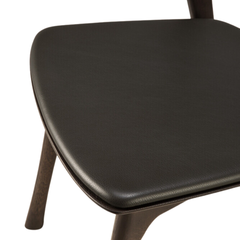 The Bok Upholstered Dining Chair from Ethnicraft in brown oak with brown leather seat.