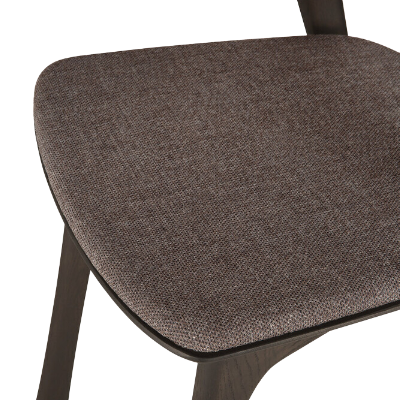 The Bok Upholstered Dining Chair from Ethnicraft in brown oak with warm brown fabric seat.