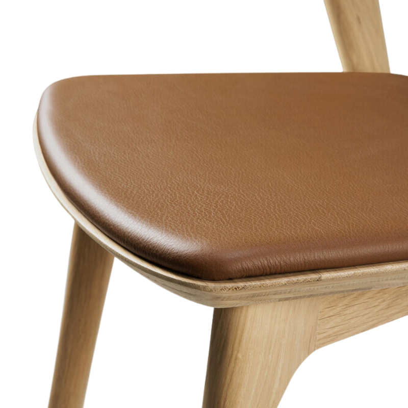 The Bok Upholstered Dining Chair from Ethnicraft in oak with cognac leather seat.