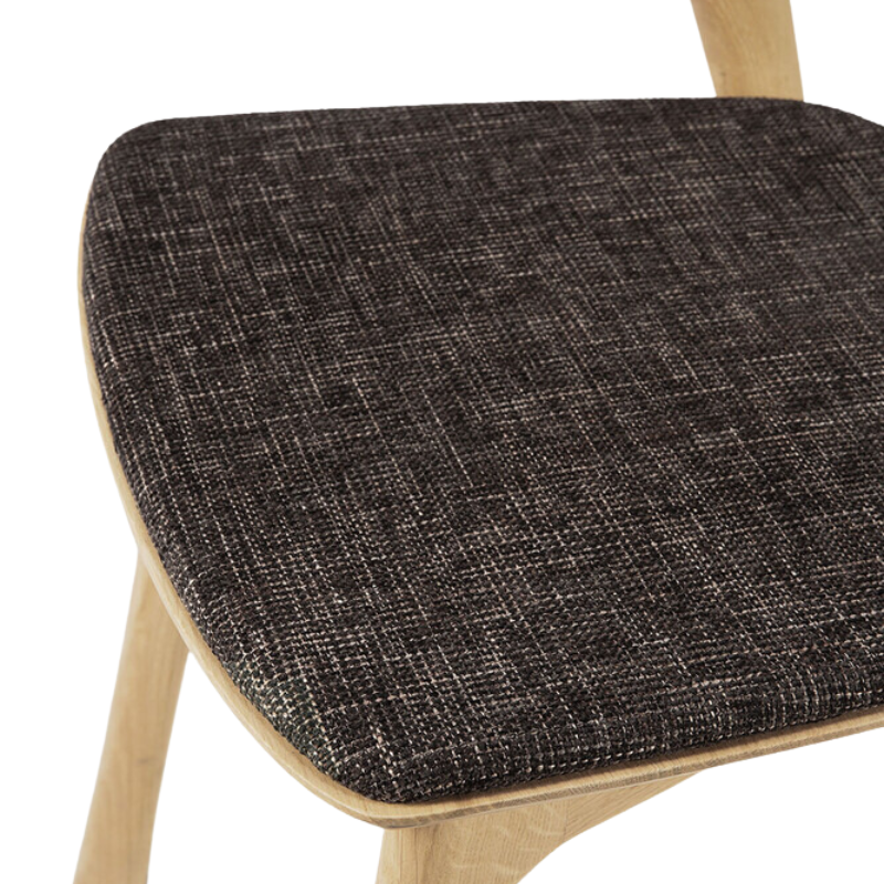 The Bok Upholstered Dining Chair from Ethnicraft in oak with dark brown fabric seat.
