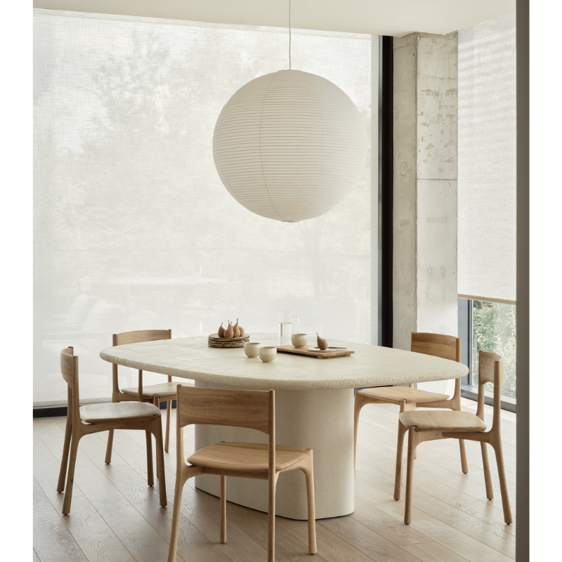 The Elements Pebble Dining Table by Ethnicraft in a modern dining room with Bok dining chairs.