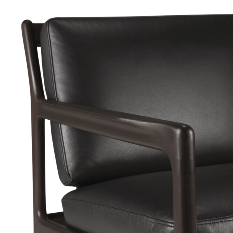 The Jack Lounge Chair from Ethnicraft with a black leather cushion focusing on the arm rest.