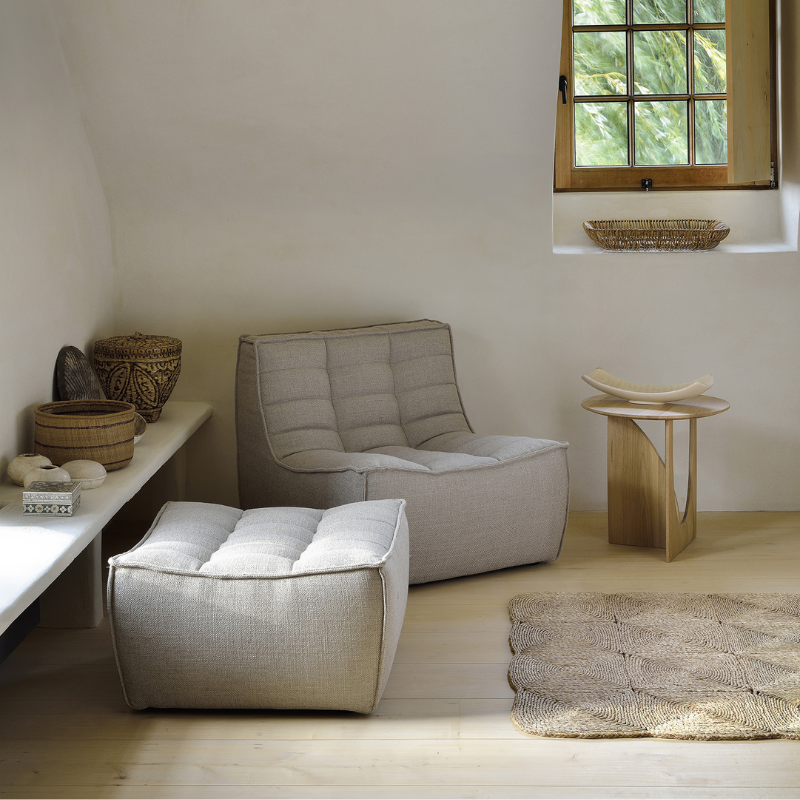 The N701 Footstool from Ethnicraft with beige standard fabric in a primary bedroom.