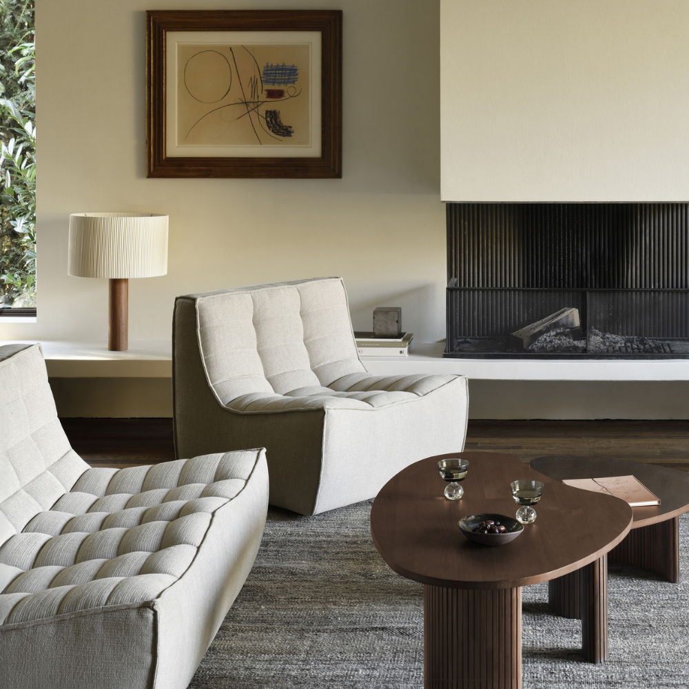 The N701 Modular Sofa from Ethnicraft with ecru eco fabric in a lounge with a fireplace.
