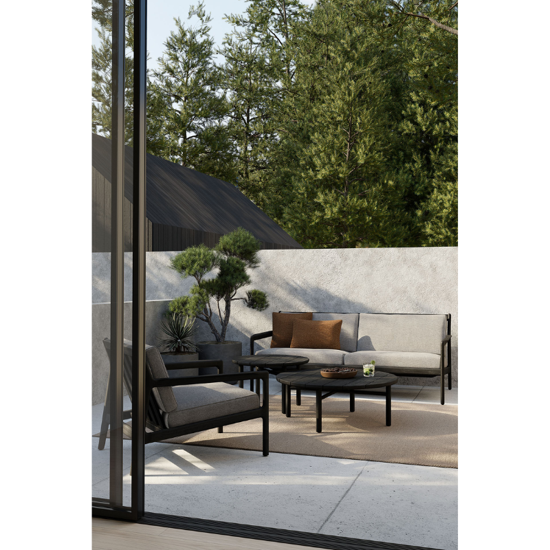 The marsala Nomad Square Outdoor Cushion from Ethnicraft in an outdoor living space.