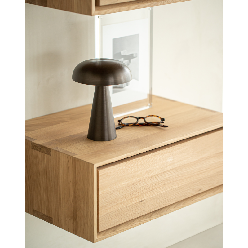 The Nordic II Hanging Bedside Table from Ethnicraft in a primary bedroom.