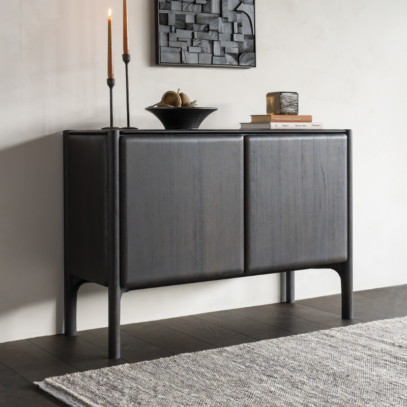 The PI Sideboard from Ethnicraft in dark brown teak in a dining room.