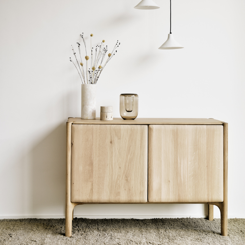 The PI Sideboard from Ethnicraft in oak in a bedroom.