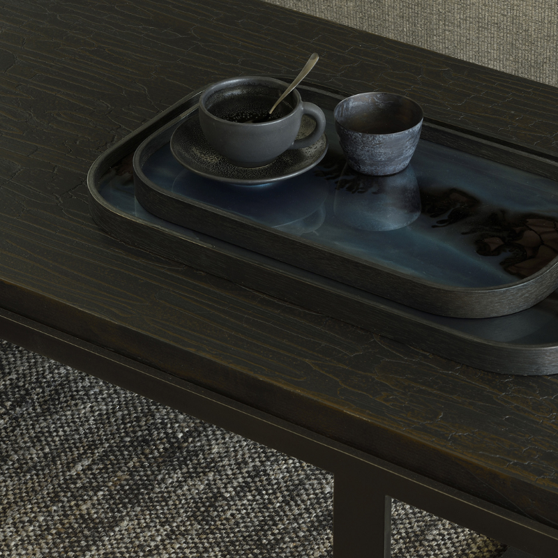 The Rectangular Organic Valet Tray Slate from Ethnicraft in a living room on a table.