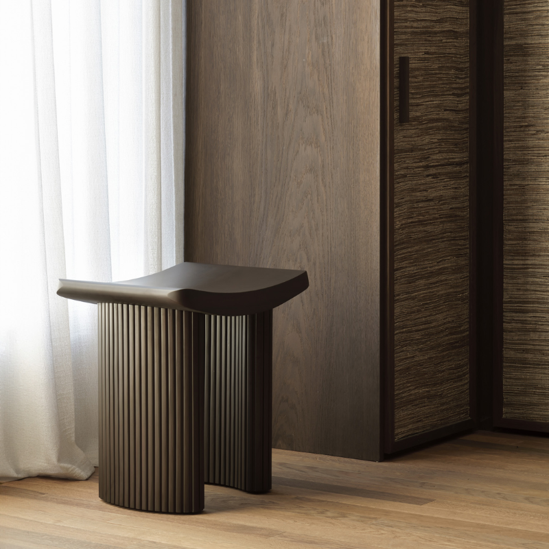 The Roller Max Stool from Ethnicraft in a bedroom.