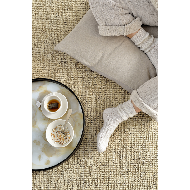 The round gold mist Organic Glass Tray from Ethnicraft with tea and food on the floor used as serving tray.