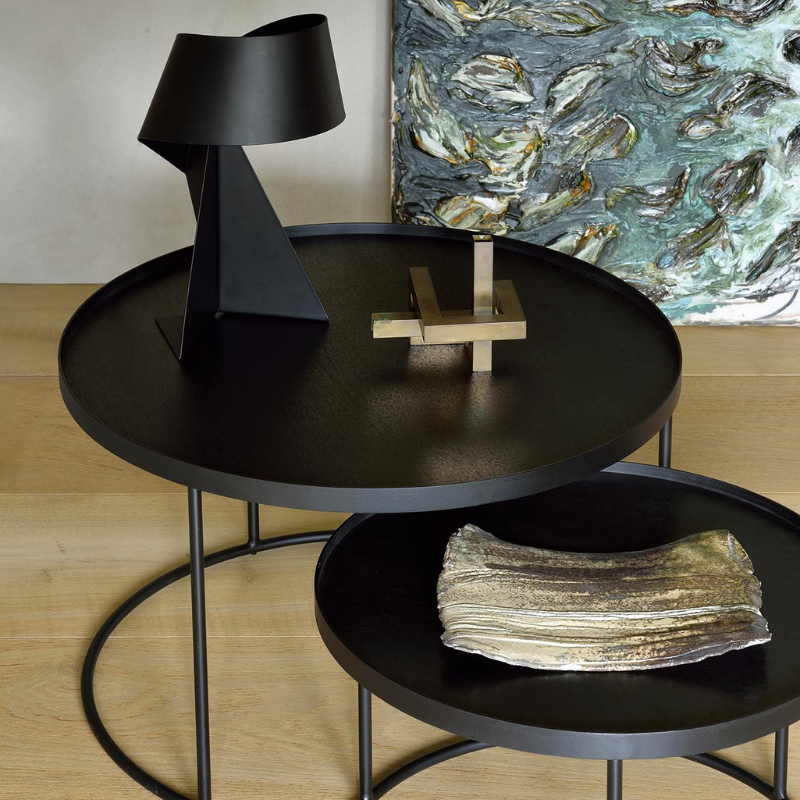 The medium and large Round Tray Coffee Table Set from Ethnicraft in a primary bedroom.