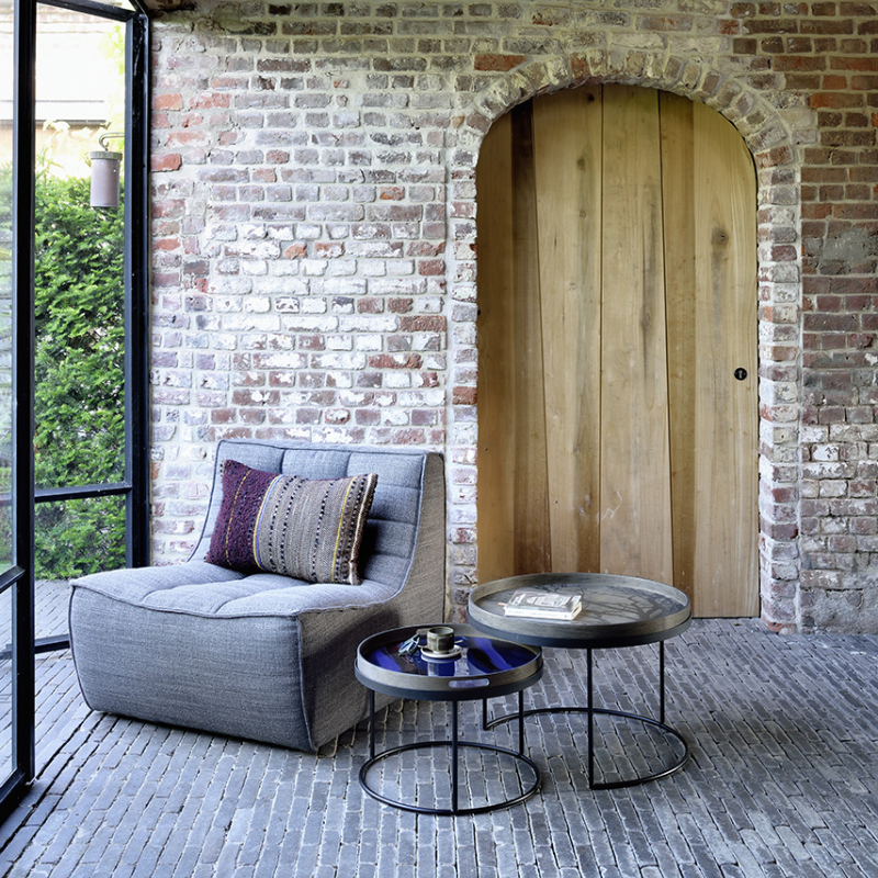 The small and medium Round Tray Coffee Table Set from Ethnicraft in a living space.
