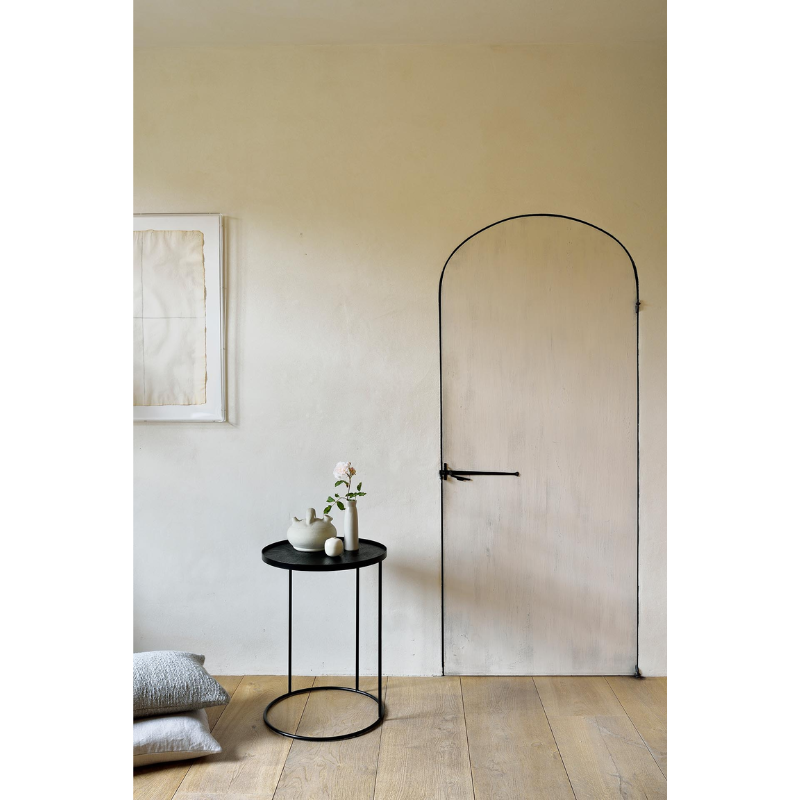 The Round Tray Side Table from Ethnicraft in an entryway.