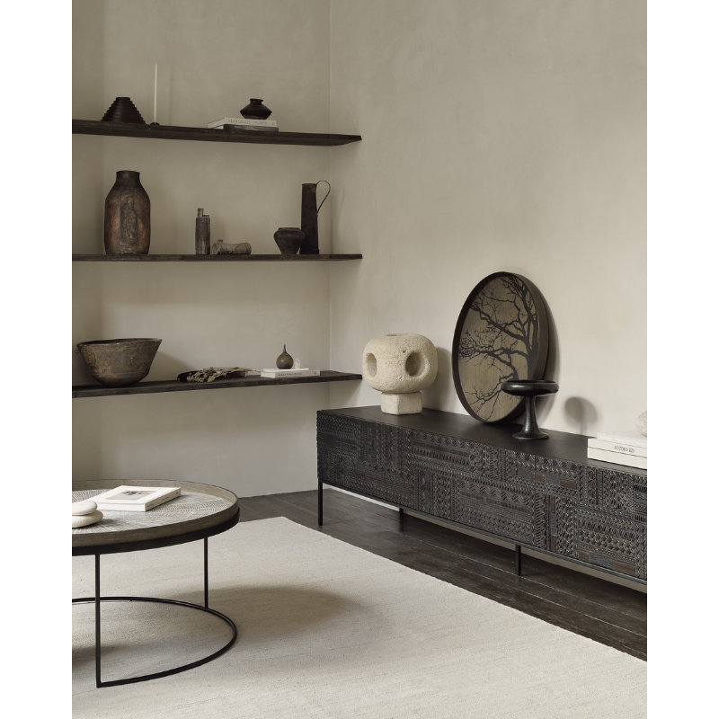 The black round Tree Wooden Tray from Ethnicraft in a dining room.