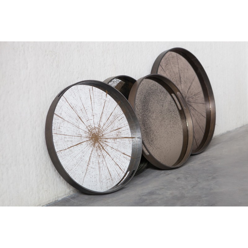 The small round Slice Mirror Tray from Ethnicraft in a living space with other trays.