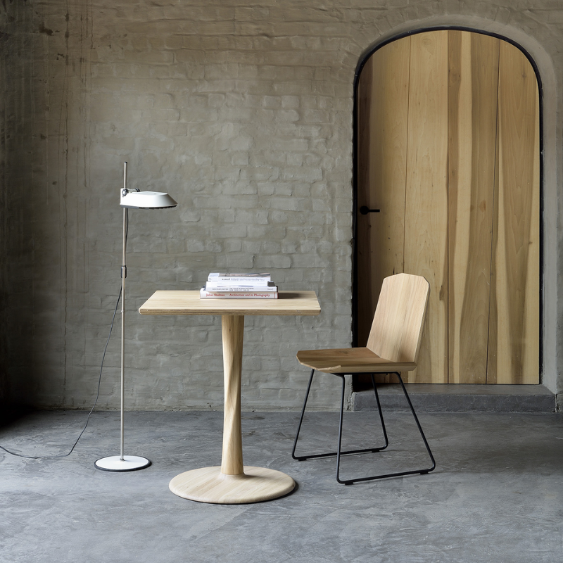 The Torsion Square Dining Table from ethnicraft in a hall.