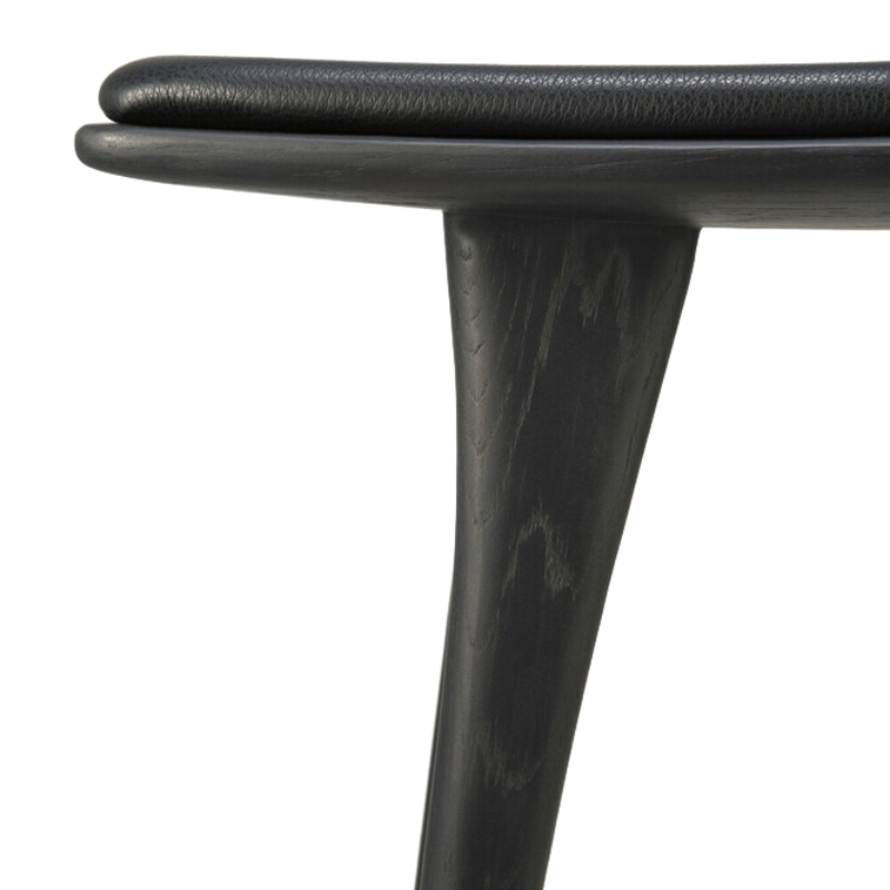 The Upholstered Osso Counter Stool from Ethnicraft with black oak wood and black leather upholstery.