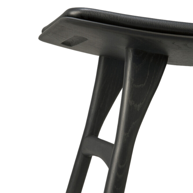 The Upholstered Osso Dining Stool from Ethnicraft with black oak and black leather in detail.