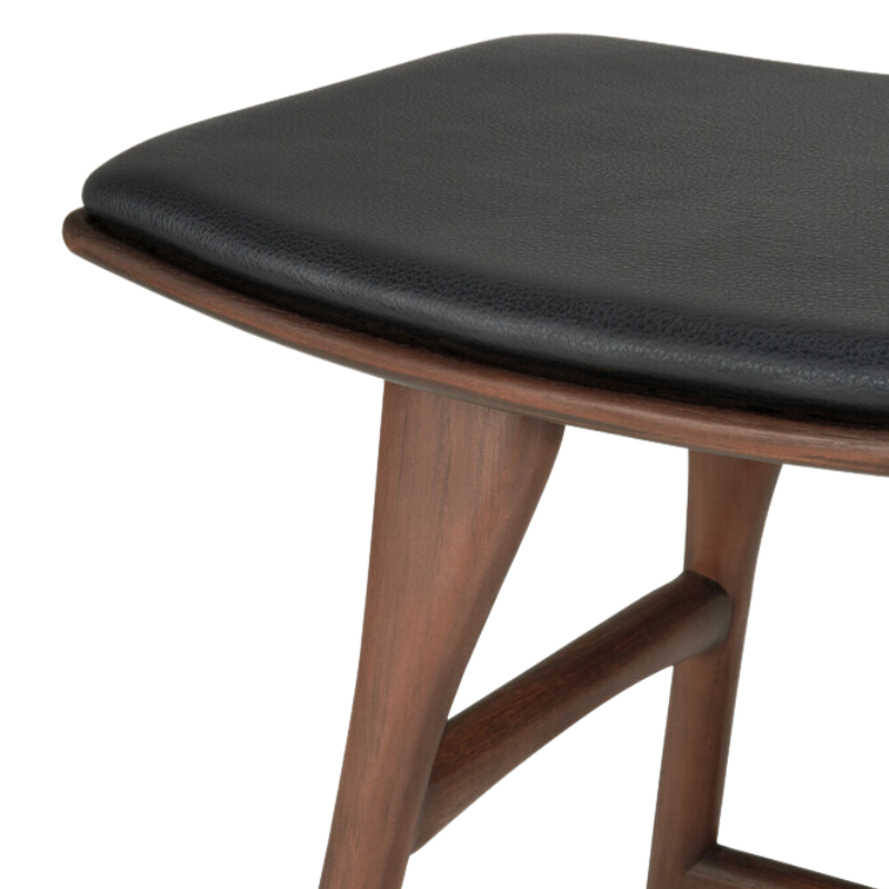 The Upholstered Osso Dining Stool from Ethnicraft with brown teak and black leather close up.