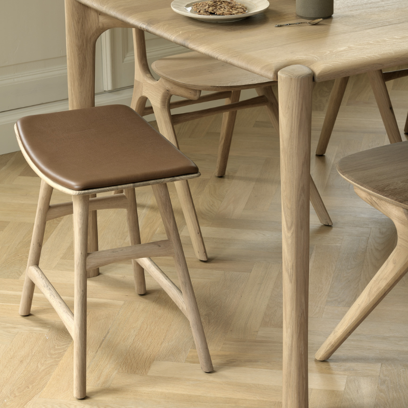 The Upholstered Osso Dining Stool from Ethnicraft in a dining room.
