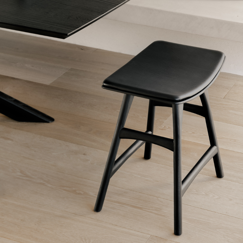 The Upholstered Osso Dining Stool from Ethnicraft at a dining table.